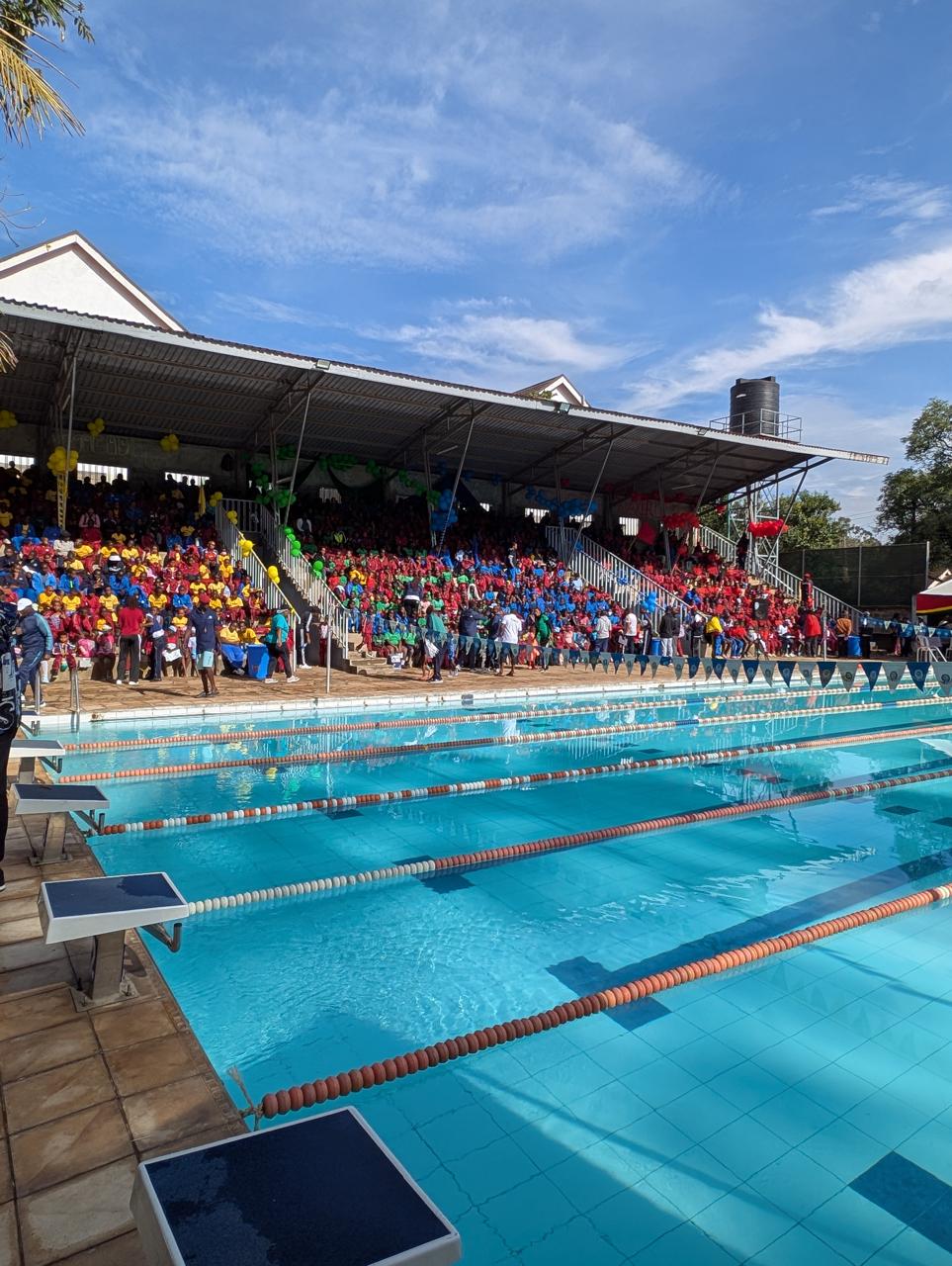 Learners gathered beside the swimming pool at a school event